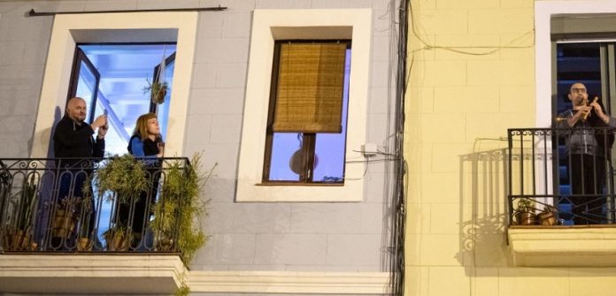 Vecinos que aplauden en el balcón y cuelgan carteles 