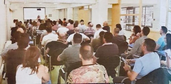 Funcionarios de prisiones recibiendo un curso de formación hacinados en un aula de clases, con altas temperaturas.
