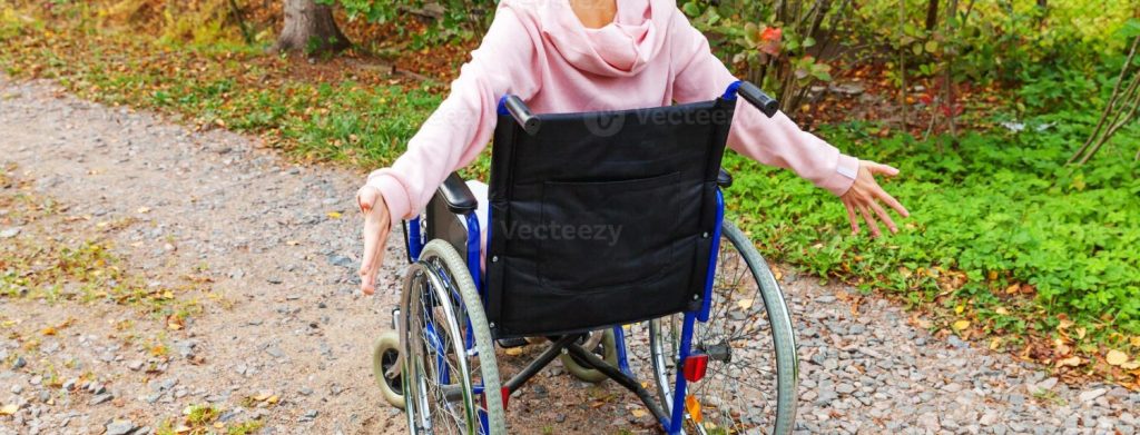 young happy handicap woman in wheelchair on road in hospital park enjoying freedom paralyzed girl in invalid chair for disabled people outdoor in nature rehabilitation concept photo Moncloa