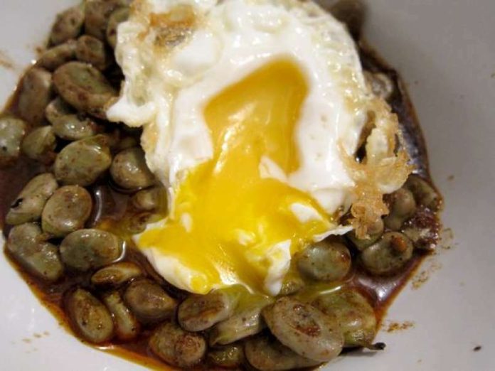 Deléitate con una explosión de sabores: habas salteadas que envuelven unos irresistibles huevos rotos, quedarás como un ‘rey’