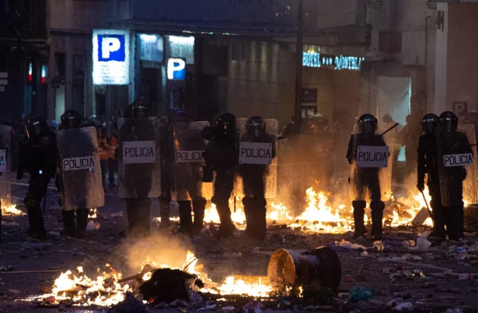 Agentes de la Policía Nacional rodeados de fuego y piedras durante los graves disturbios de 2019