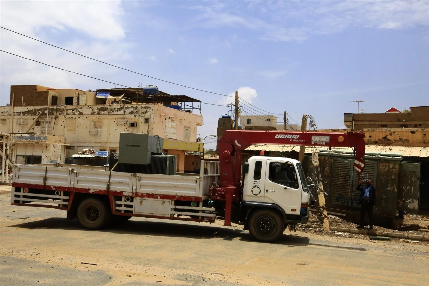 Trabajadores de electricidad cambian un transformador en una zona residencial de la ciudad de Omdurman, Sudán