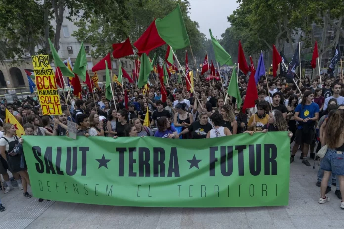 Varias personas durante una manifestación ecologista contra el modelo turístico y económico, del passeig Lluís Companys al Monumento a Colón, a 8 de junio de 2024, en Barcelona, Catalunya (España).