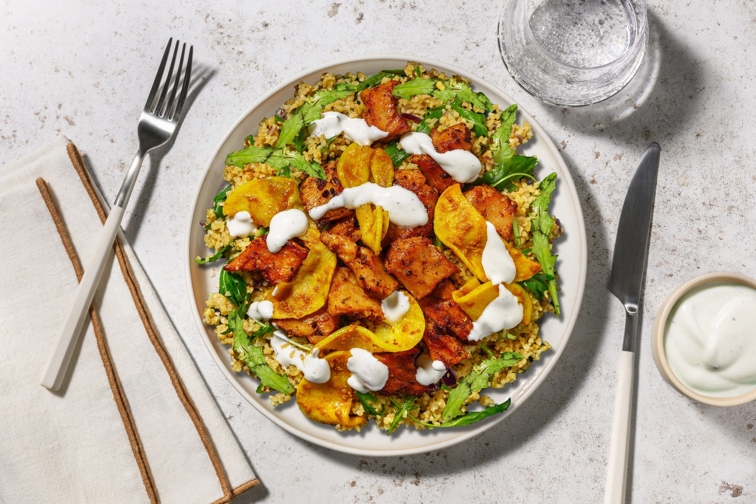 Heura con manzana a la curcuma con salsa de yogur sobre bulgur con rucula 1 scaled Moncloa