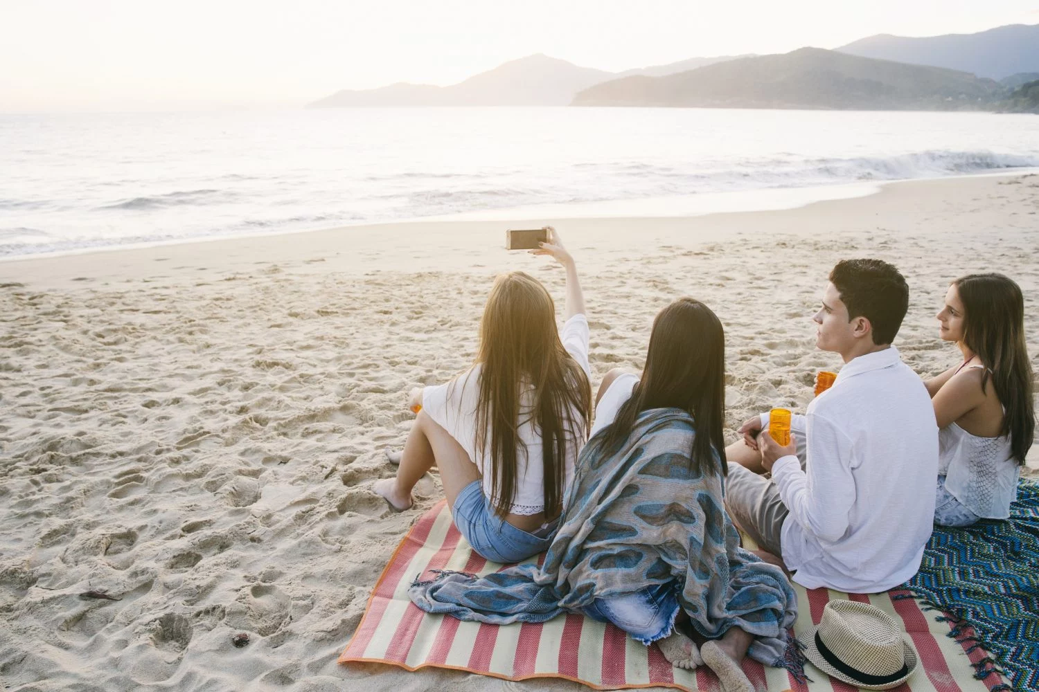 Jóvenes haciendo turismo en una playa.